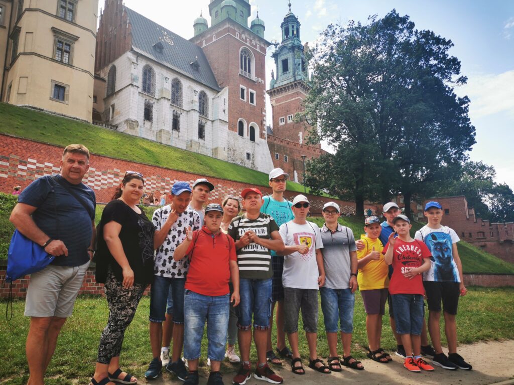 Grupa osób przez wzgórzem zamkowym na Wawelu. 