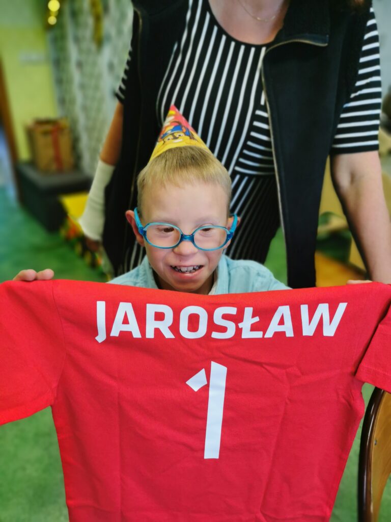 Chłopiec trzyma koszulkę sportową z napisem Jarosław i numerem 1 