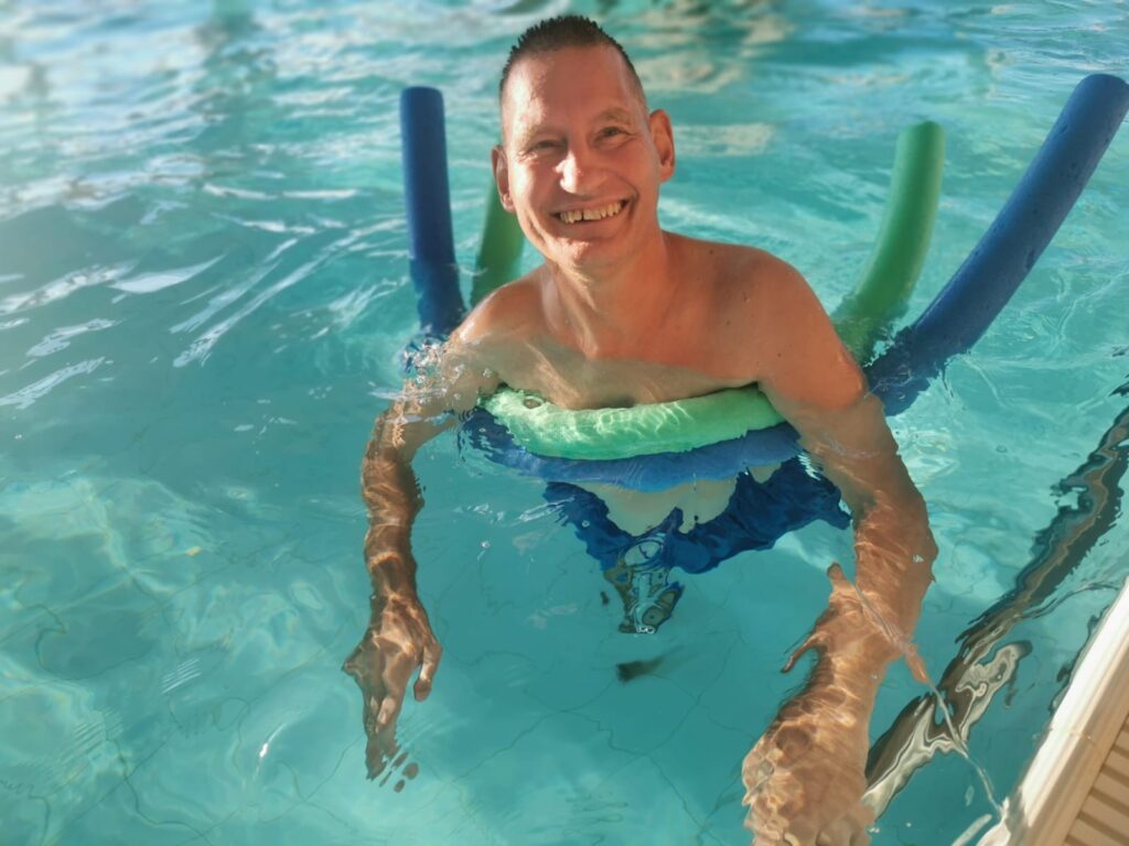 Uśmiechnięty mężczyzna pływający w basenie