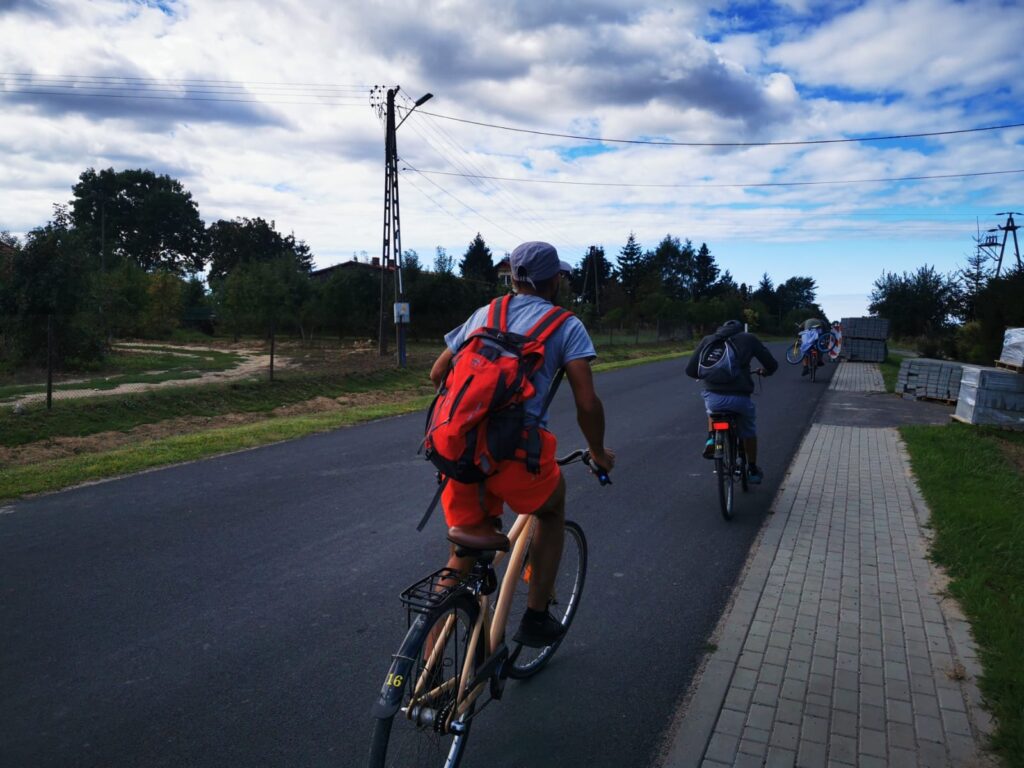 Grupa rowerzystów jedzie drogą 