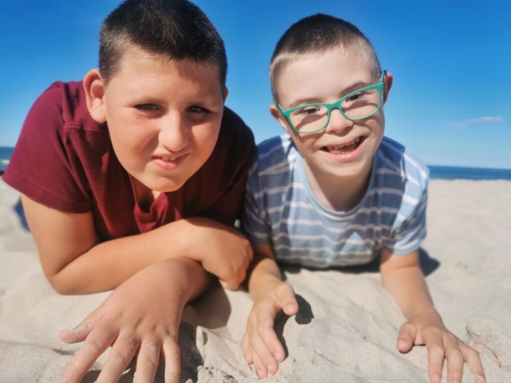 dwoje chłopców leżących na plaży 