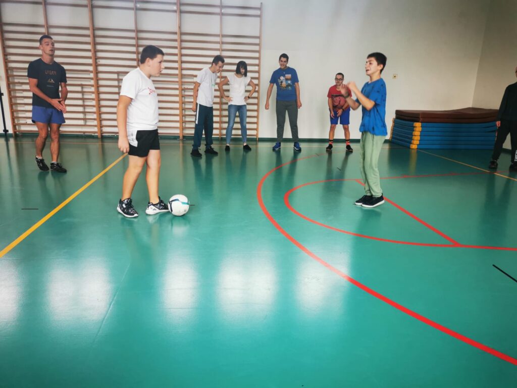 grupa chłopców na sali sportowej gra w piłkę nożną 