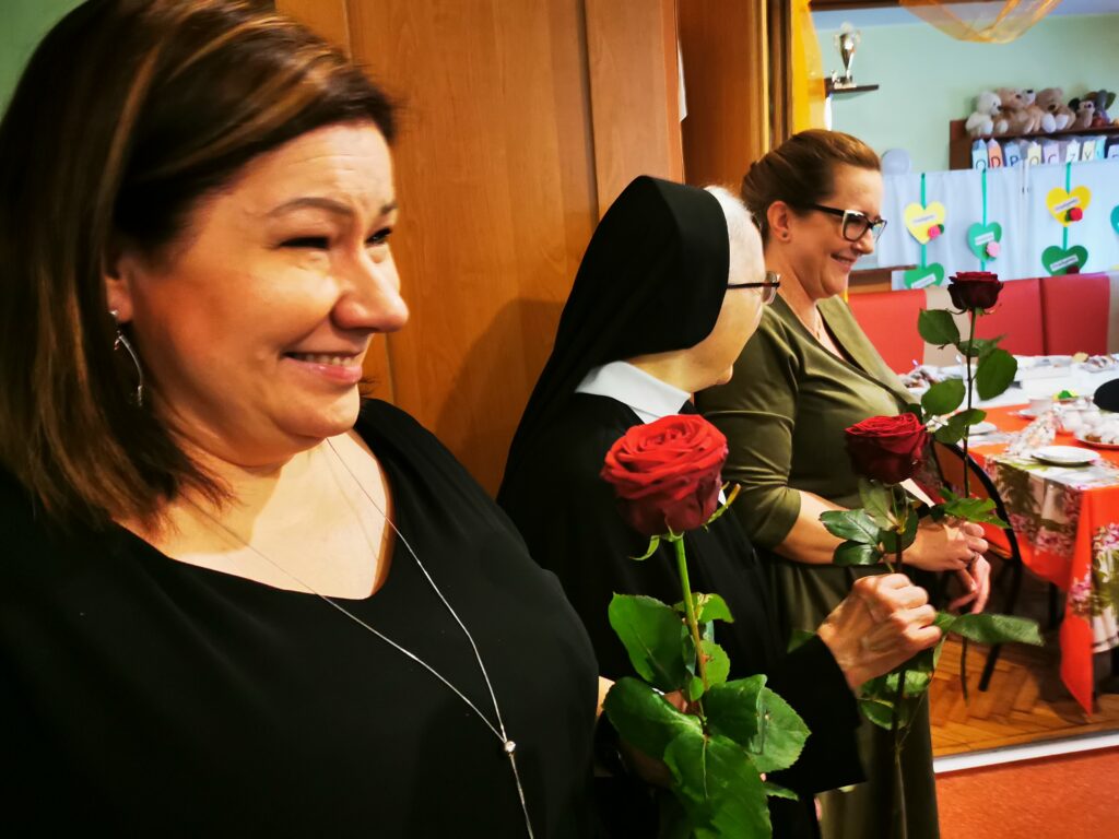 Uśmiechnięta kobieta trzyma różę 