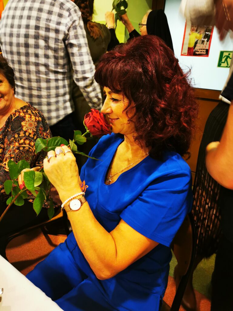Kobieta wąchająca różę. 