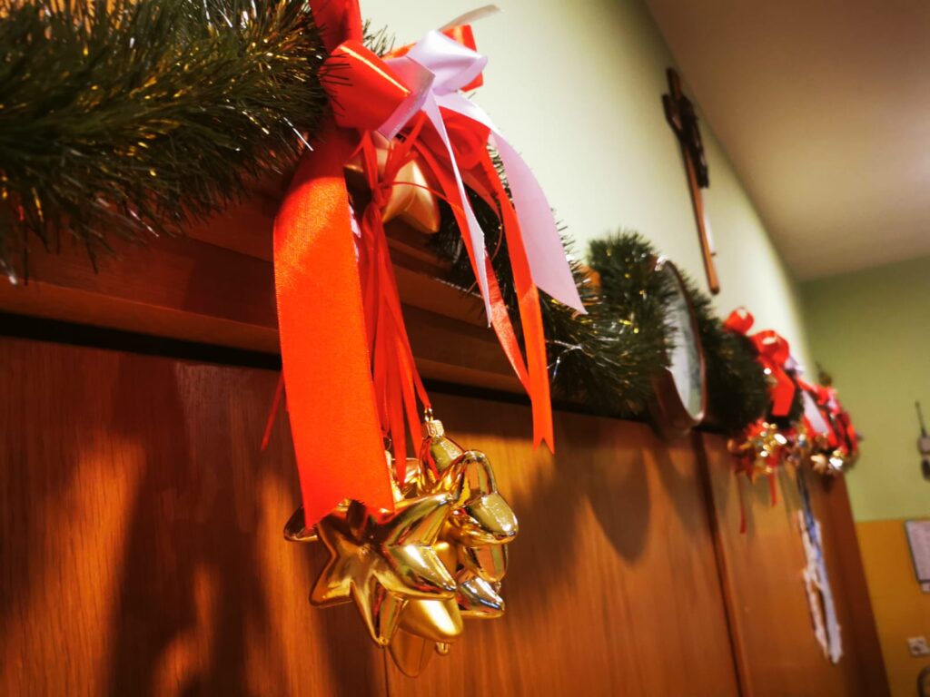 Świąteczna dekoracja: girlanda ze świątecznymi ozdobami zawieszona nad drzwiami. 