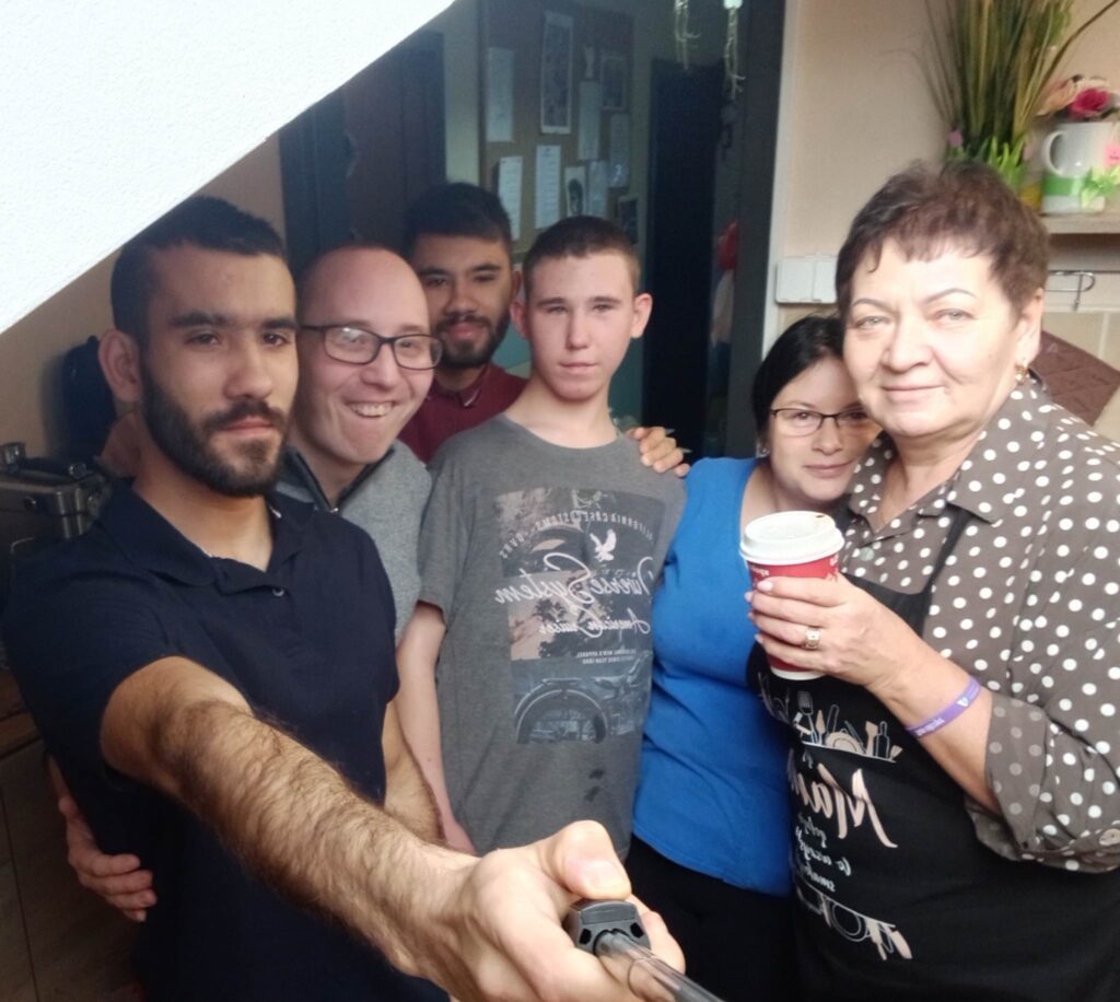Grupa osób pozuje do zdjęcia sypu selfie. 