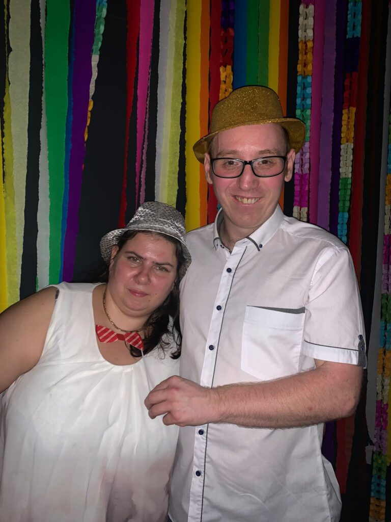 Kobieta i mężczyzna w kapeluszach i białych koszulach pozują do zdjęcia. 