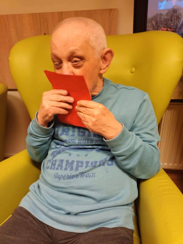 Starszy mężczyzna całuje kartkę. 