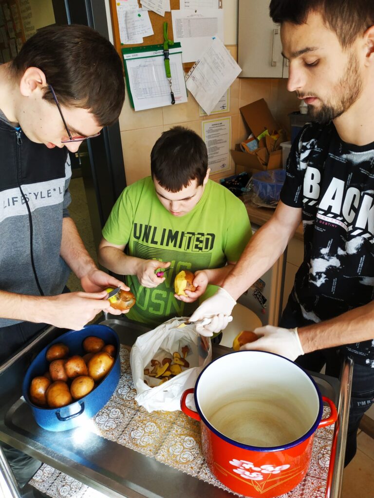 Trzech chłopaków podczas obierania ziemniaków. 