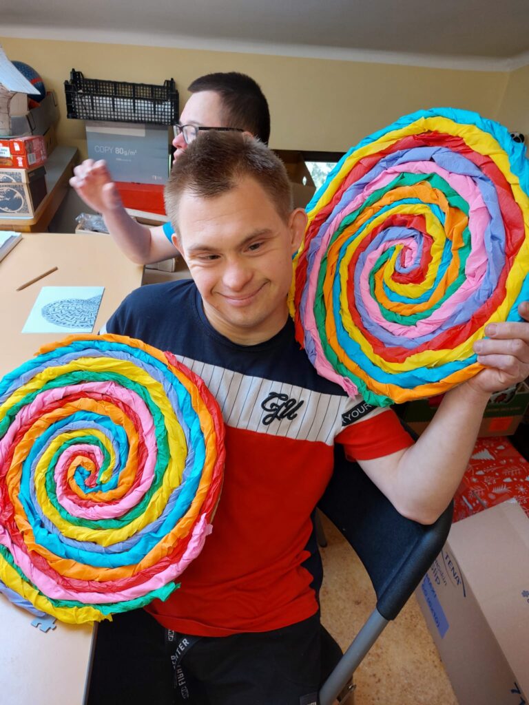 Chłopak trzymający duże kolorowe okręgi. 