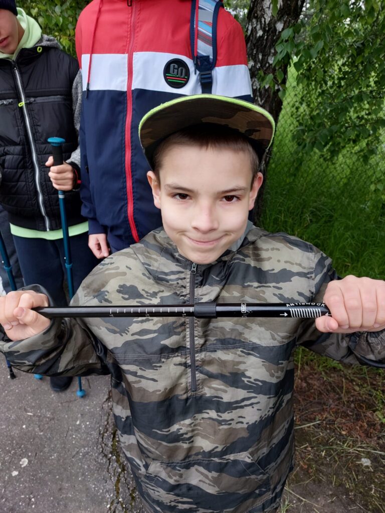 Chłopiec pokazujący swój kijek do nordic walking. 