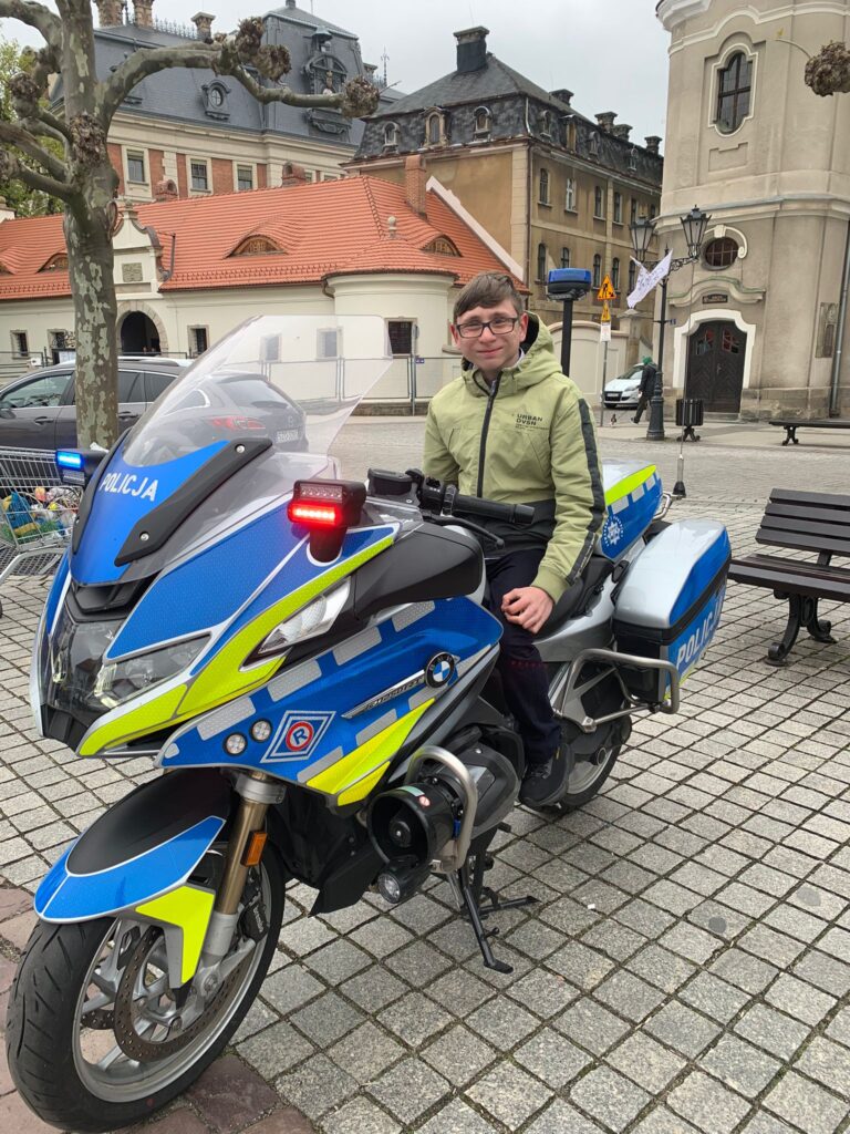 Chłopiec siedzący na policyjnym motocyklu. 