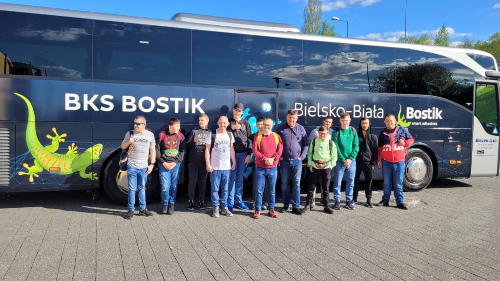 Grupa osób przed autokarem z napisem "Bostik" Bielsko-Biała. 