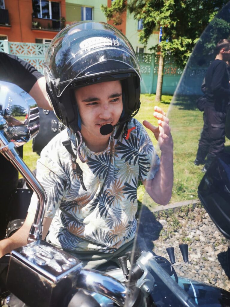 chłopiec na motocyklu w kasku z mikrofonem. 