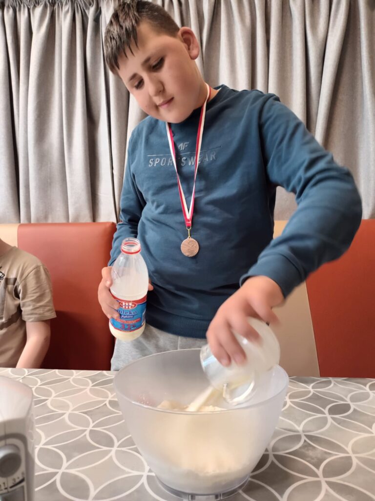 chłopiec wlewający mleko do miski 