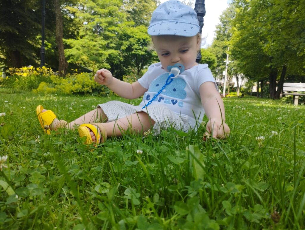 Mały chłopczyk siedzący na trawie