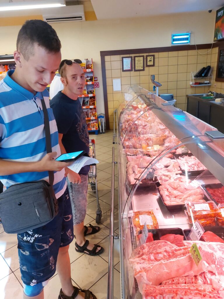 Dwóch chłopaków przy stoisku mięsnym w sklepie 
