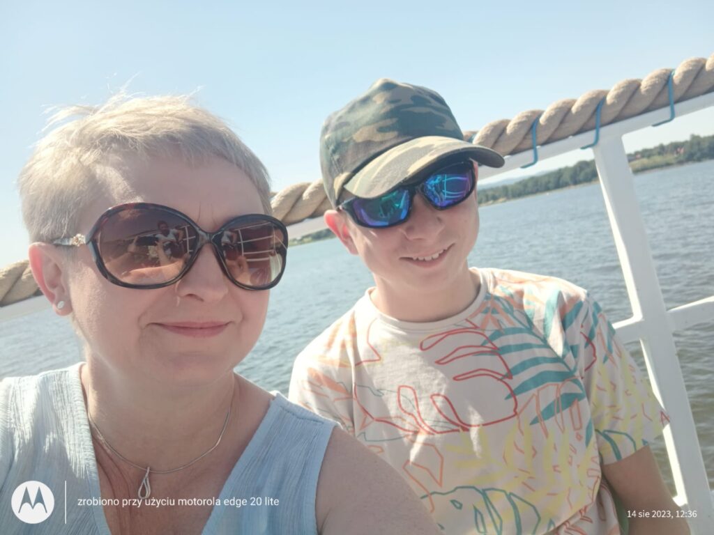Kobieta i chłopiec robią zdjęcie typu selfie przed jeziorem 
