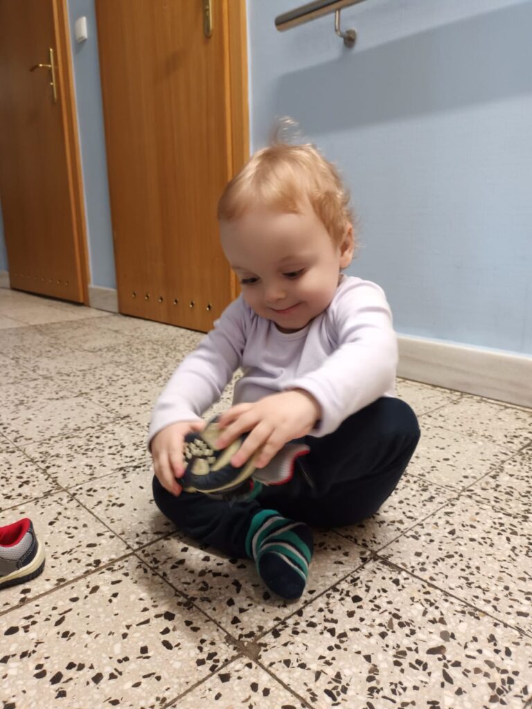 Mały chłopiec zakładający buty 