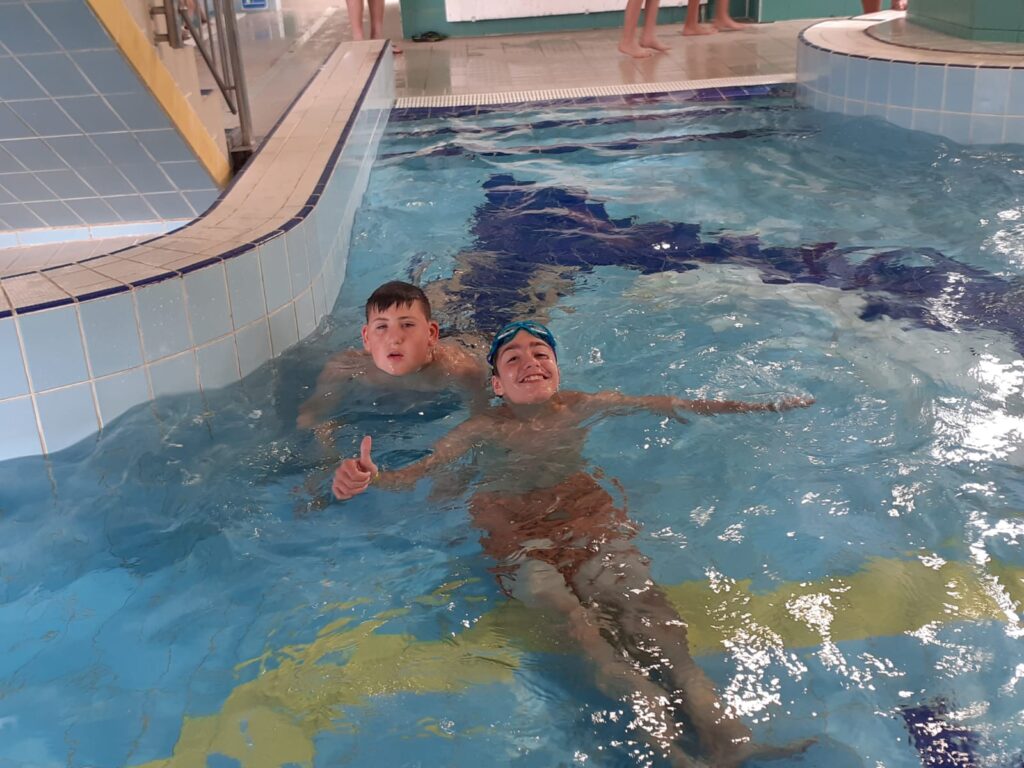 dwoje chłopaków pływających w basenie 