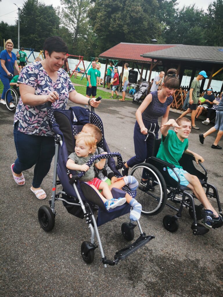 Kobiety tańczące z dziećmi na wózkach inwalidzkich 