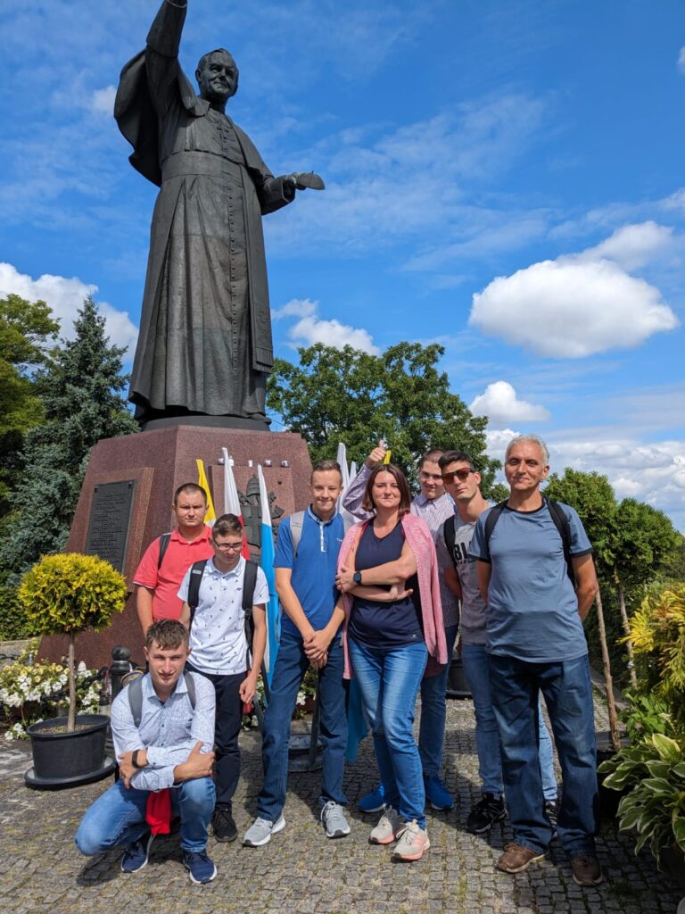 Grupa osób pod pomnikiem Jana Pawła II 