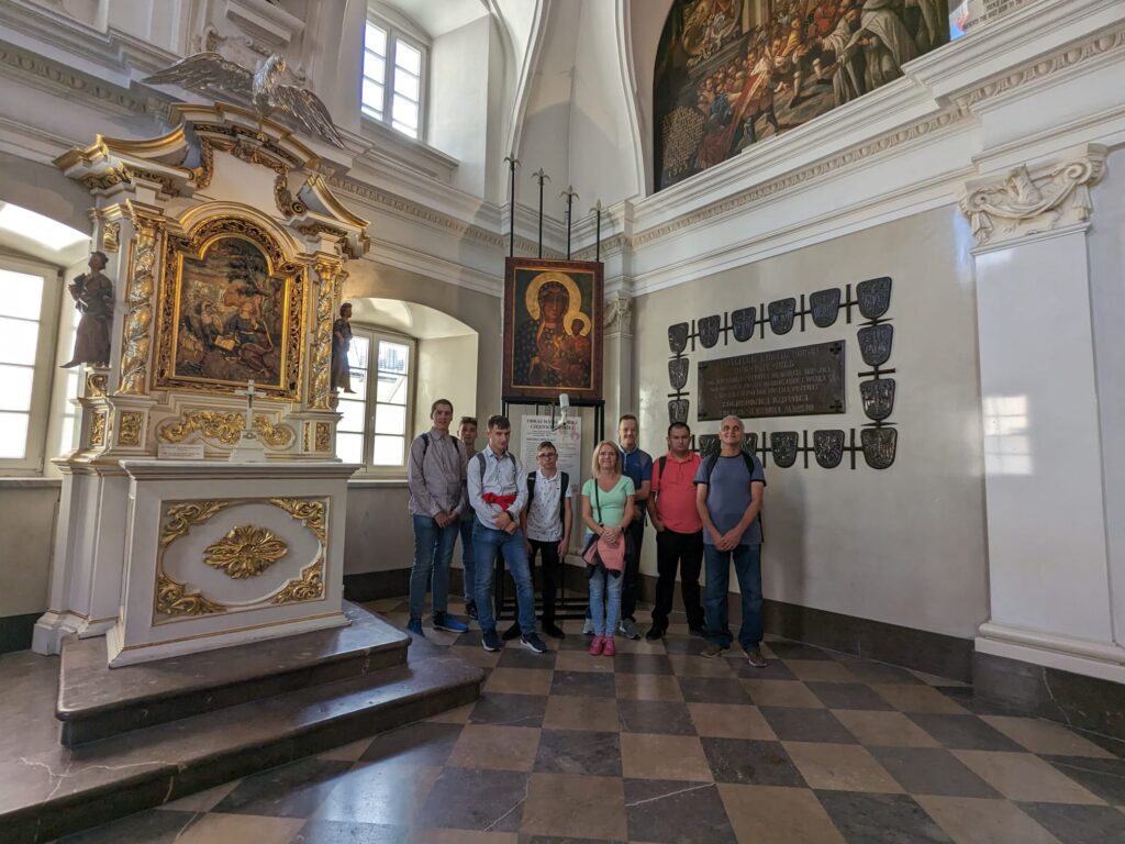 Grupa osób pod obrazem Matki Boskiej Częstochowskiej 