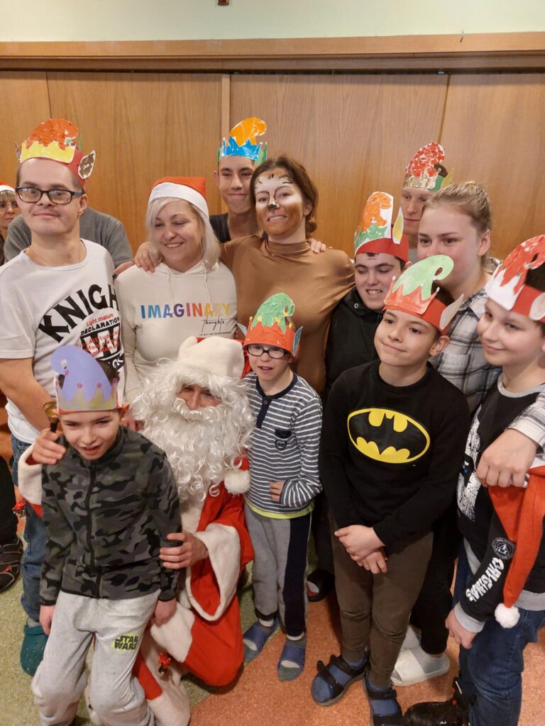 zdjęcie grupowe kilku chłopaków w czapkach elfa z osobą w stroju św. Mikołaja. 