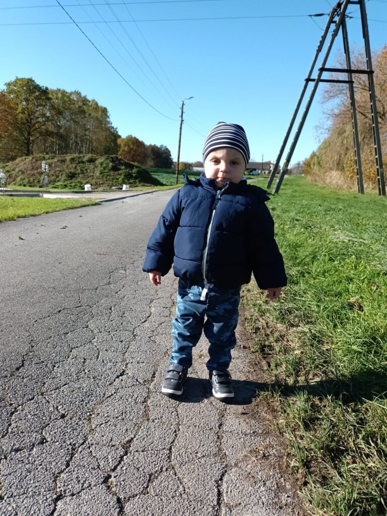 Mały chłopiec idący poboczem. 