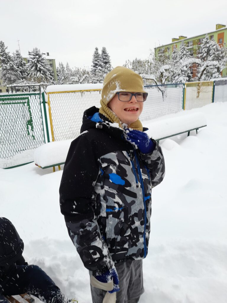 Chłopiec podczas zabawy w śniegu. 