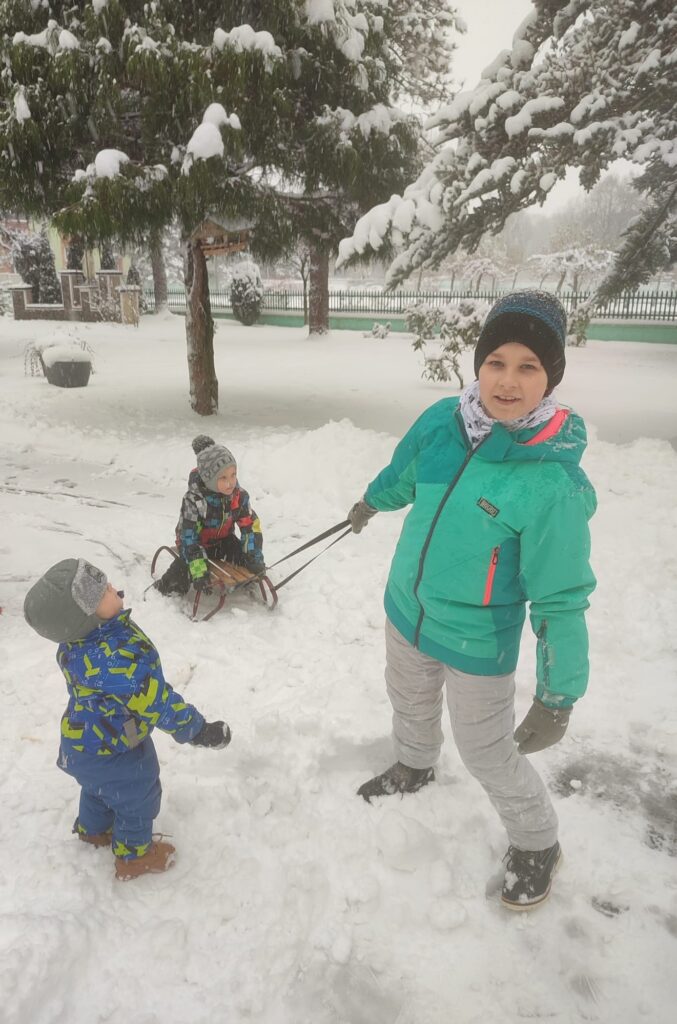 Grupa chłopaków podczas zabawy w śniegu 