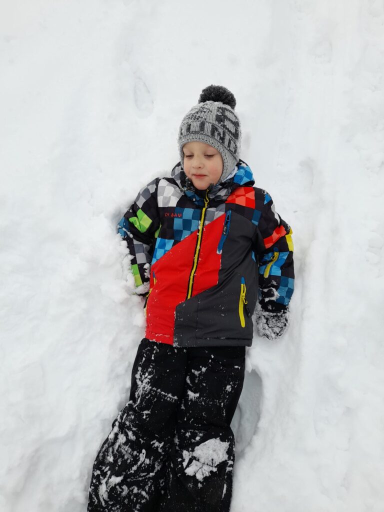Chłopiec podczas zabawy w śniegu. 
