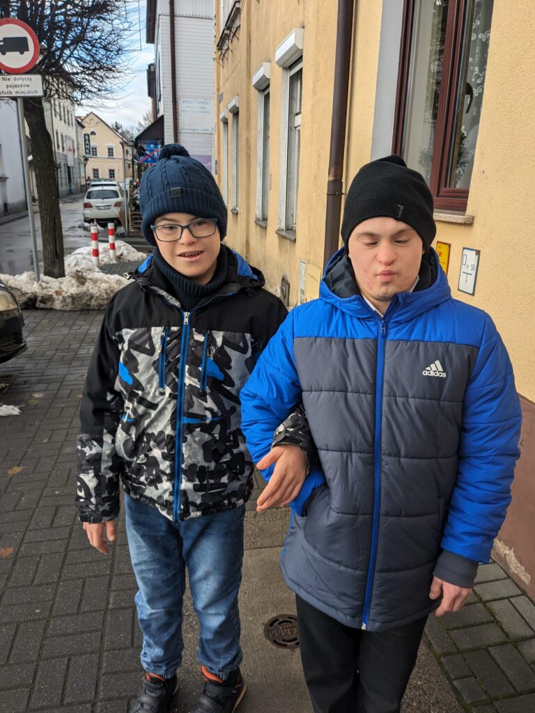 dwóch chłopców idących ulicą. 