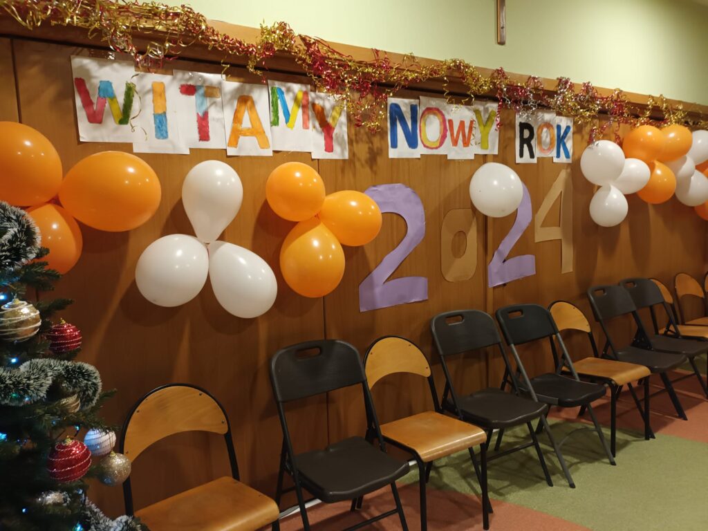 Ściana z balonami i kolorowymi literami tworzącymi napis "Witamy Nowy Rok 2024" 