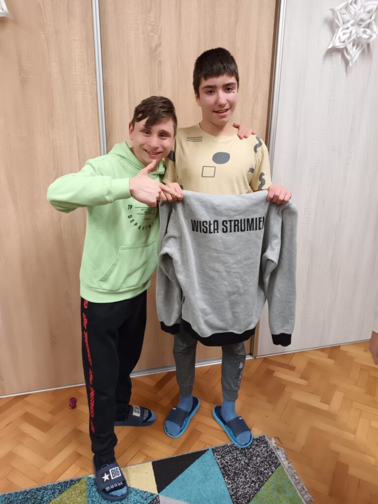 Dwóch chłopaków trzymających bluzę  z napisem "Wisła-Strumień" 