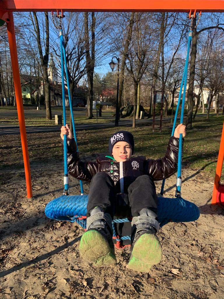Chłopiec na chuśtawce w parku 