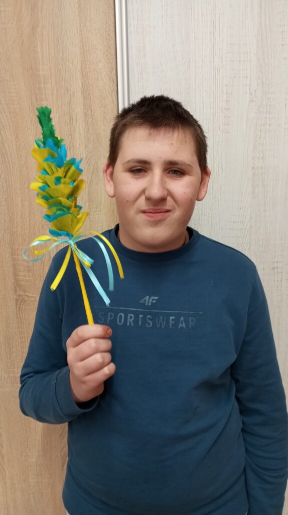 Chłopiec prezentujący wykonaną przez siebie palmę 