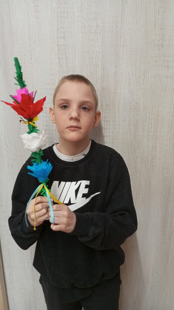 Chłopiec prezentujący wykonaną przez siebie palmę 