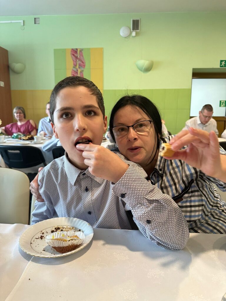 Kobieta i chłopiec jedzą ciasto. 
