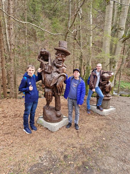 troje chłopaków przy drewnianych rzeźbach 