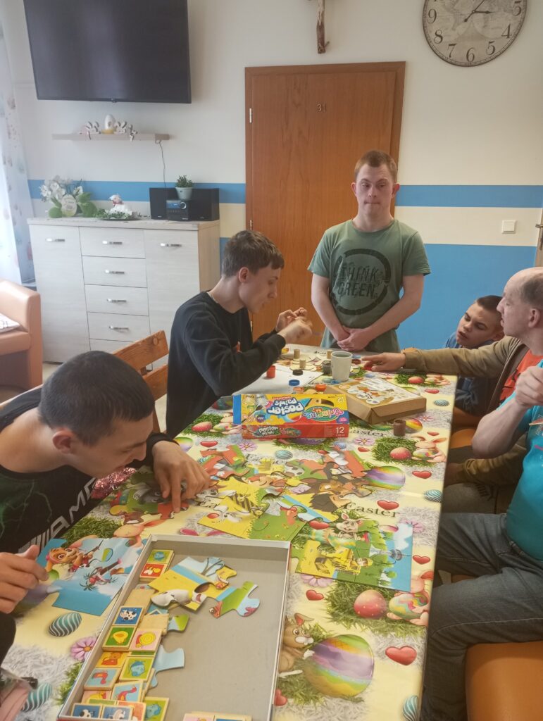 Chłopcy układający puzzle przy stole. 